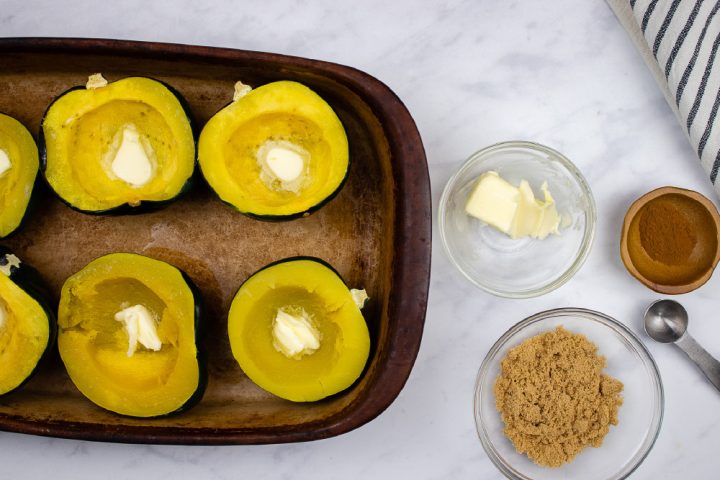 Acorn squash halved and steamed in a pan with a pat of butter inside the indentation of each half