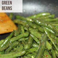 Seasoned green beans in a skillet with a wooden spoon with text Seasoned Green Beans - Add Salt & Serve logo