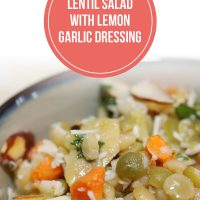 Lentils, carrots, artichokes, and almonds in a bowl topped with dressing and shredded parmesan cheese, garnished with parsley; text Lentil Salad with Lemon Garlic Dressing - Add Salt & Serve logo