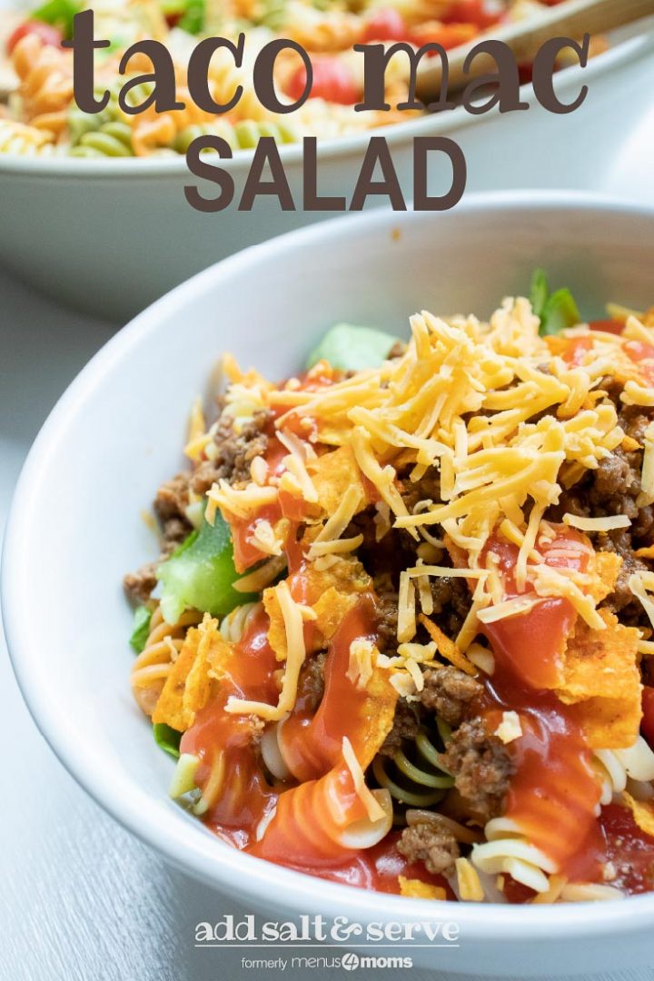 Bowl of seasoned ground beef, spiral pasta, lettuce, halved tomatoes, nacho cheese Doritos, and French salad dressing with shredded cheddar cheese on top with text Taco Mac Salad Add Salt & Serve