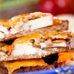 Image of bread with mayo, apple slices, and sunflower seeds topped with melted cheddar and text Open-faced Apple Cheddar Melt Sandwich