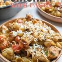 Bowl of shell pasta with tomatoes, feta cheese, and balsamic vinegar with text Mediterranean Chicken with Pasta