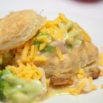 Puff Pastry with broccoli, chicken, and shredded cheddar cheese on a white plate