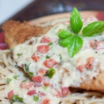 breaded cooked chicken breast smothered in a cream sauce with basil and red peppers