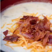 Baked potato soup topped with shredded cheddar cheese and chopped bacon.