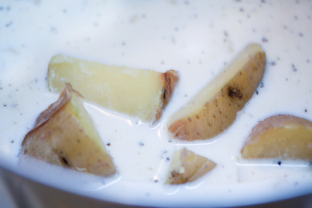 Chopped potatoes in a bowl of baked potato soup.