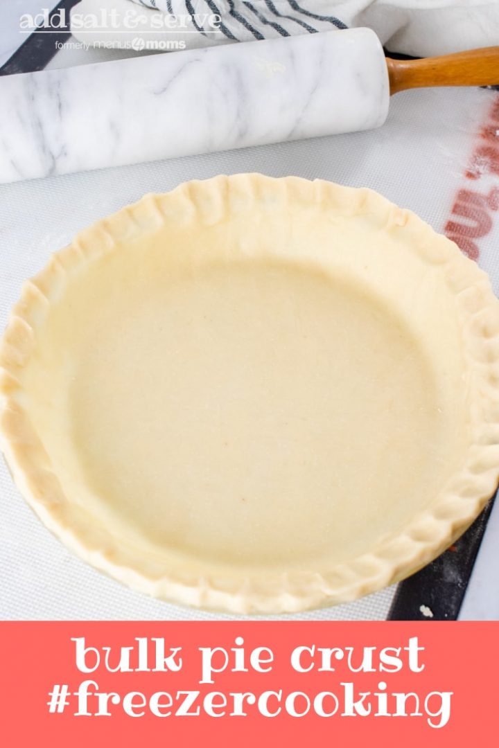 Unbaked pie crust in a pie pan with a marble rolling pin and flour sack towel in the background and text Bulk Pie Crust #freezercooking