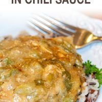 Chicken with chili cream sauce on a bed of rice on a white plate. There is a fork at the top of the plate. Text creole chicken in chili sauce add salt & serve former menus4moms