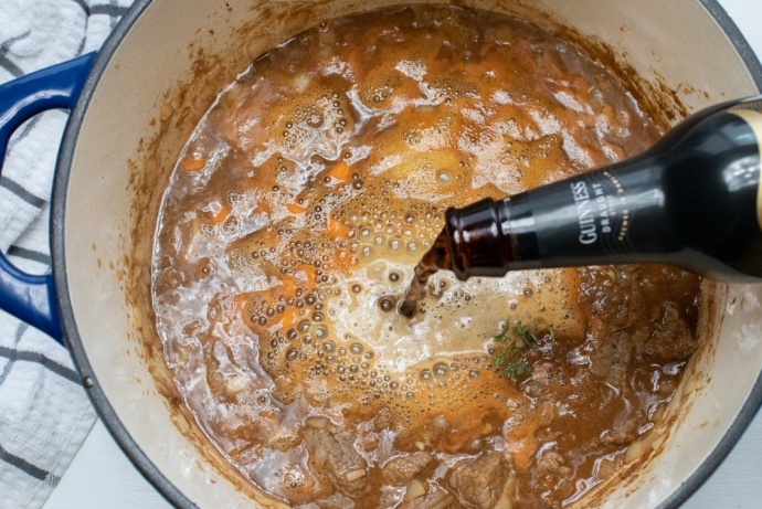 Pot of Beef Stew with Guinness beer pouring in
