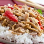 Chopped chicken with red peppers and mushrooms in a creamy sauce over white rice and garnished with chow mein noodles