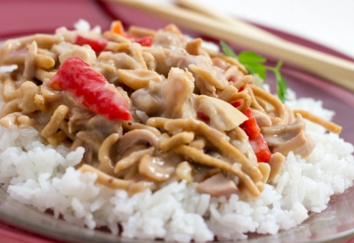 Chopped chicken with red peppers and mushrooms in a creamy sauce over white rice and garnished with chow mein noodles
