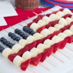Blueberries, strawberries, and bananas threaded on bamboo skewers in the design of an American flag