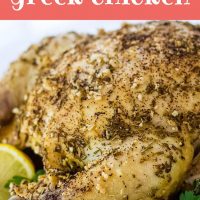 Whole roasted chicken with a dried rosemary and minced garlic rub on a white plate, garnished with lemon slices and parsley. Text Crockpot Greek Chicken Add Salt & Serve formerly menus4moms