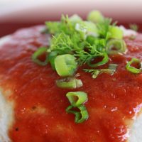 Burrito with red sauce poured over it and garnished with cilantro and chopped green onions and text Easy Homemade Enchilada Sauce; Add Salt & Serve logo