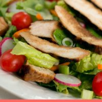 Salad of romaine lettuce pieces, grape tomatoes, and carrots topped with sliced grilled chicken and text Asian Chicken Salad #plannedleftovers Add Salt & Serve
