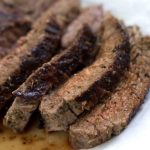 Seaasoned and grilled flank steak sliced and plated with juices