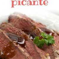 Four slices of sliced roast beef on a white plate with brown gravy on top. Garnished with a sprig of parsley; text Roast Beef Picante Add Salt & Serve formerly Menus4Moms