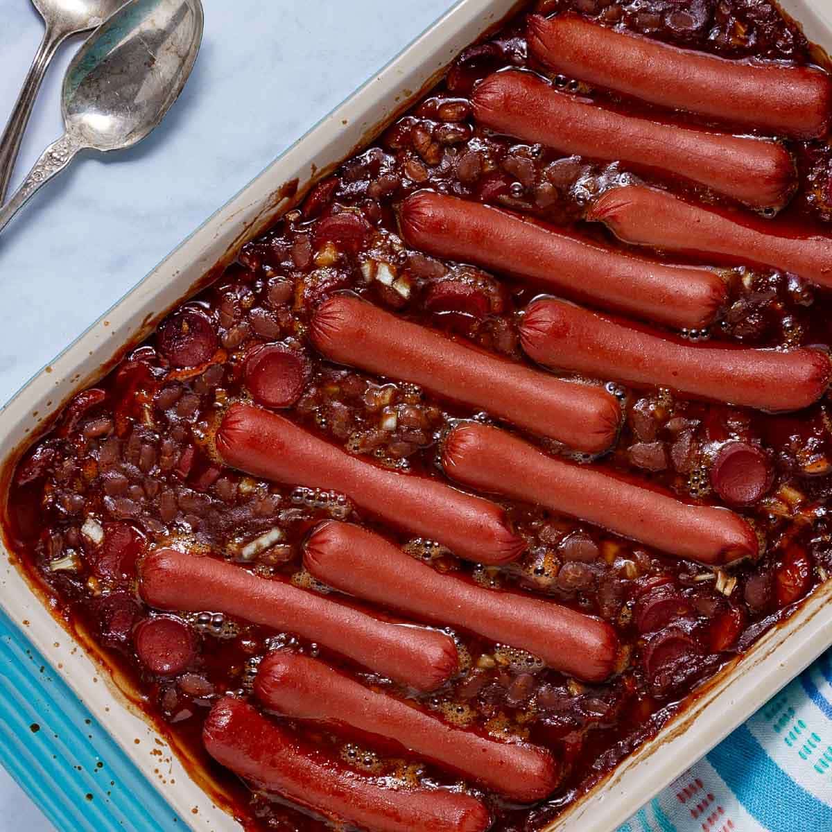 Baked franks and beans in a baking dish.