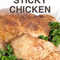 Whole cooked chicken covered with spices, on a white plate garnished with a lot of parsley. Text Slow Cooker Sticky Chicken Add Salt & Serve formerly menus4moms