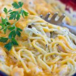 Cheddar Chicken Spaghetti with parsley being scooped out with a pasta utensil