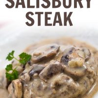 Mushroom Salisbury Steak on a white plate garnished with a sprig of parsley. Text Mushroom Salisbury Steak Add Salt & Serve formerly menus4moms