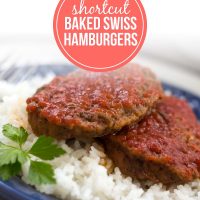 Two Baked Swiss Hamburgers on a bed of rice on a plate.