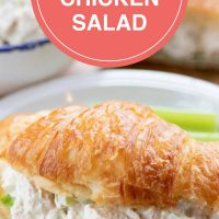 Chicken salad and lettuce on a croissant, all on a white plate. In the background is a bowl of chicken salad and more croisssants. Text is Best Rotisserie Chicken Salad - Add Salt & Serve logo