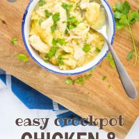 Chicken and dumplings garnished with parsley in a white bowl with a blue rim. There is a spoon with a dumpling and some broth. The bowl is on a wooden cutting board on top of a blue napkin with white stripes, all on a white marble counter; text add salt & serve formerly menus4moms easy crockpot chicken & dumplings