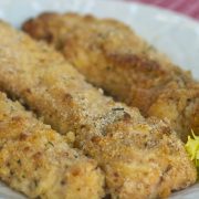 Three breaded chicken tenders on white plate