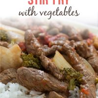 Cooked strips of beef with onions, brocolli florets, diced tomatoes, and mushrooms on a bed of rice; text Beef Stir-fry with Vegetables - Add Salt & Serve logo