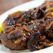 Hamburger patty covered with sliced mushrooms and onions and gravy.
