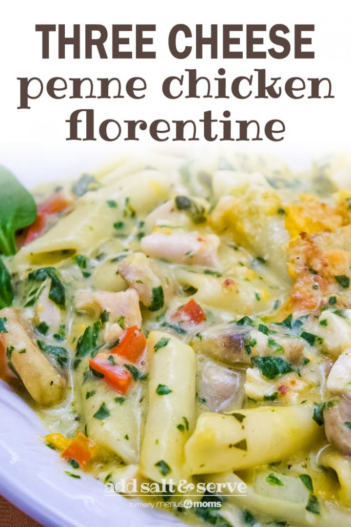 Penne pasta with mushrooms, diced red bell pepper, chopped spinach, and cubed chicken in a cream of chicken sauce, topped with shredded cheddar cheese and garnished with two baby spinach leaves on a white plate. Text three cheese penne chicken florentine add salt & serve formerly menu4moms
