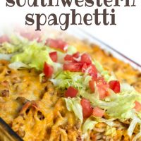 Clear casserole dish with spaghetti noodles, ground beef, and melted cheese, topped with shredded lettuce and diced tomatoes. Text baked southwestern spaghetti add salt & serve formerly menus4moms