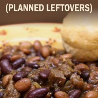 Kidney beans, pinto beans, and diced beef in a broth, all in a yellow soup bowl with red flowers. There is a biscuit on the rim of the bowl. Text barbecue beef & beans (Planned Leftovers) add salt & serve formerly menus4moms
