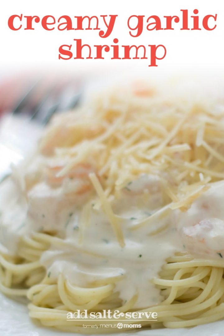 Angel hair pasta with alfredo sauce and shrimp, topped with shredded parmesan cheese, on a white plate. Text creamy garlic shrimp add salt & serve formerly menus4moms