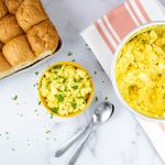 Overhead view of prepared egg salad garnished with chopped parsley and whole wheat bread to the side