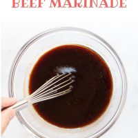 Bowl of beef marinade being mixed with a whisk. Text is Soy Garlic Beef Marinade - Add Salt & Serve logo