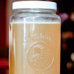 Large jar of chicken stock with a layer of fat at the top