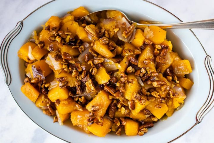 roasted-butternut-squash-candied-pecans-post-horiz-min a bowl of roasted butternut squash with candied pecans and text roasted butternut squash with candied pecans