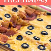 Glass casserole dish with enchiladas topped with melted cheese and sliced black olives. Text Ground Beef Enchiladas Add Salt & Serve formerly Menus4Moms
