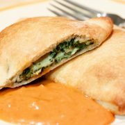 Spinach calzones on a plate with spaghetti sauce