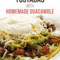 A plate with beef tostadas made with guacamole, shredded cheese, and sour cream. Text is Easy Beef Tostados with Homemade Guacamole - Add Salt & Serve logo