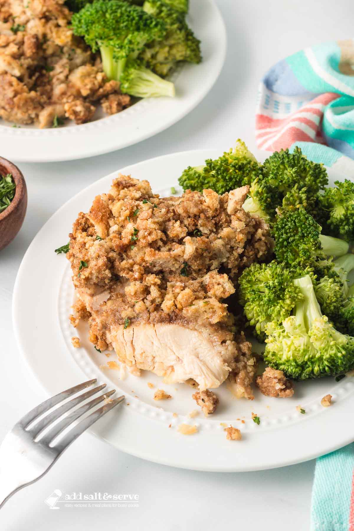 Two plates of Crockpot Chicken and Stuffing with broccoli on the side.
