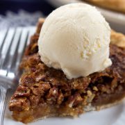 Homemade pecan pie topped with a scoop of vanilla ice cream
