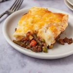 Ground beef, peas, and green beans topped with mashed potatoes and cheese