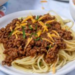 Terlingua chili over spaghetti garnished with cheese