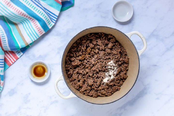 cooked ground beef with worcestershire sauce and seasoned salt in a dutch oven