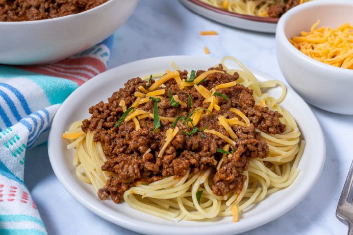 Terlingua chili over spaghetti garnished with cheese