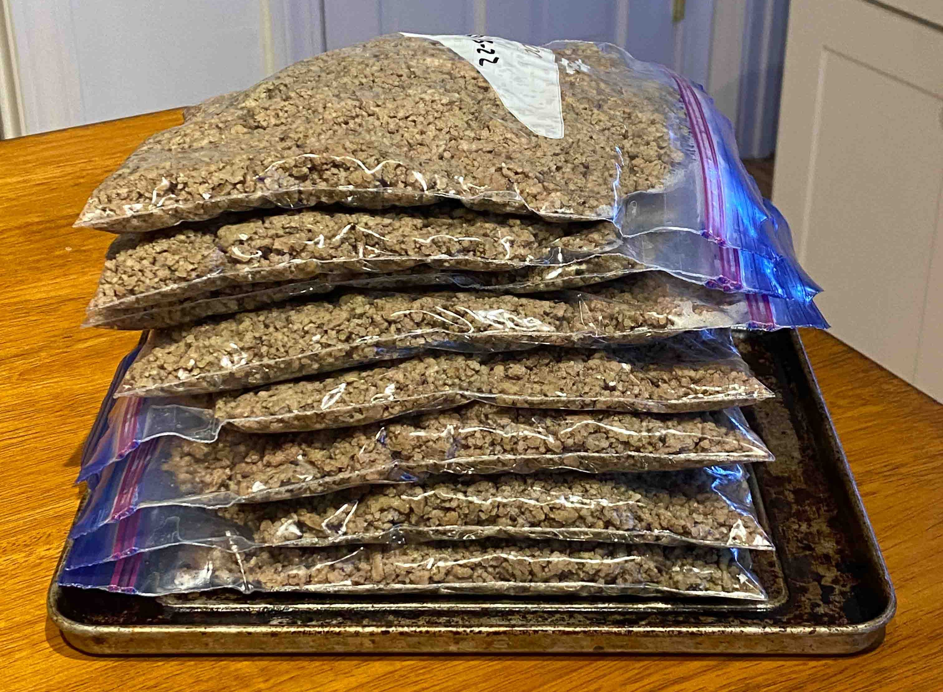 Stack of flat bags of cooked ground beef.