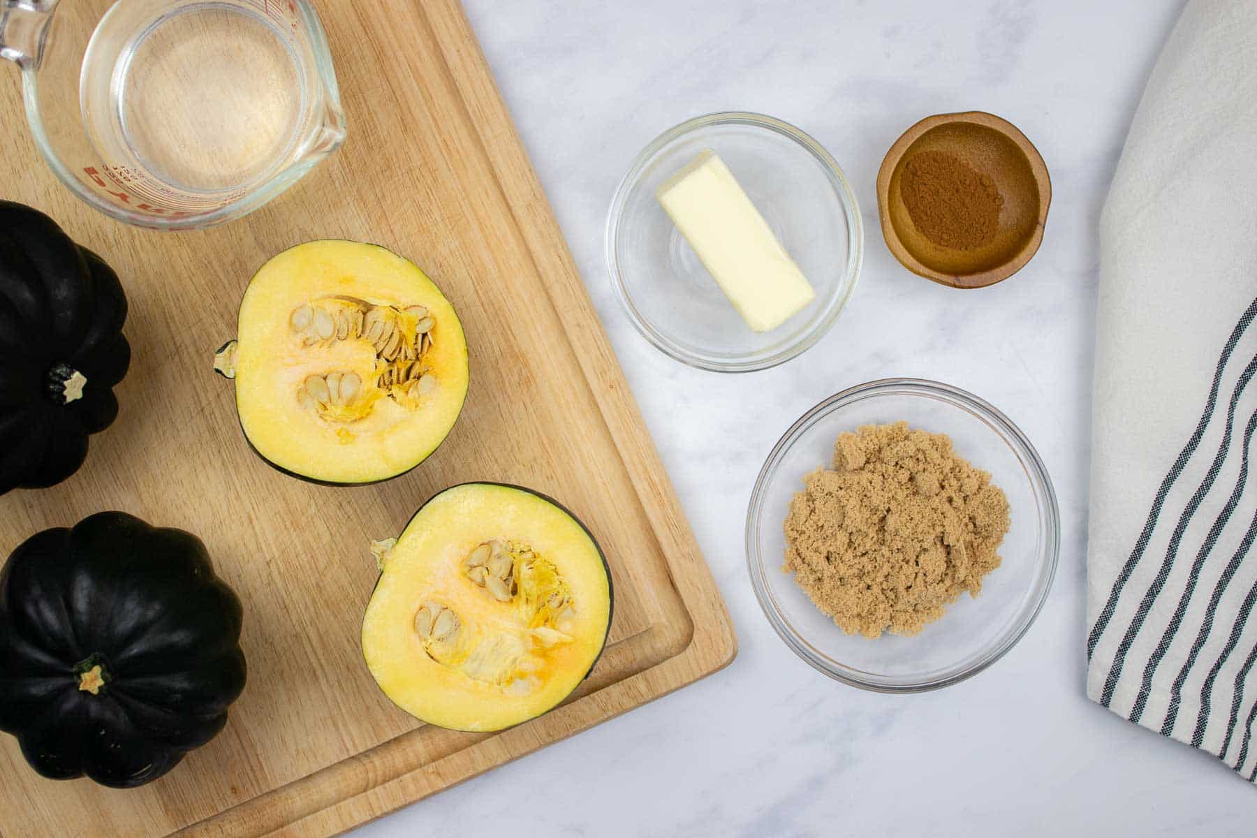 Halved acorn squash with butter, brown sugar, and cinnamon on the side.